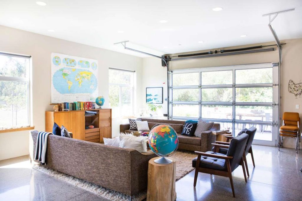 An example of a garage that's been converted into an entertainment space with couches and a rug. 