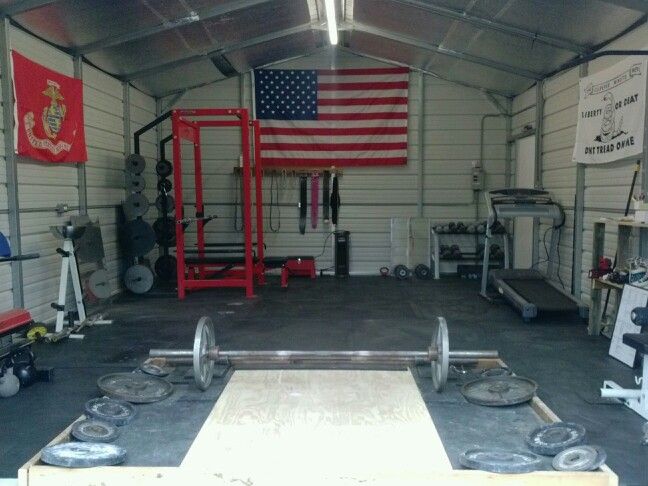 An example of a garage that's been converted into a gym with barbells, a treadmill, and dumbbells. 